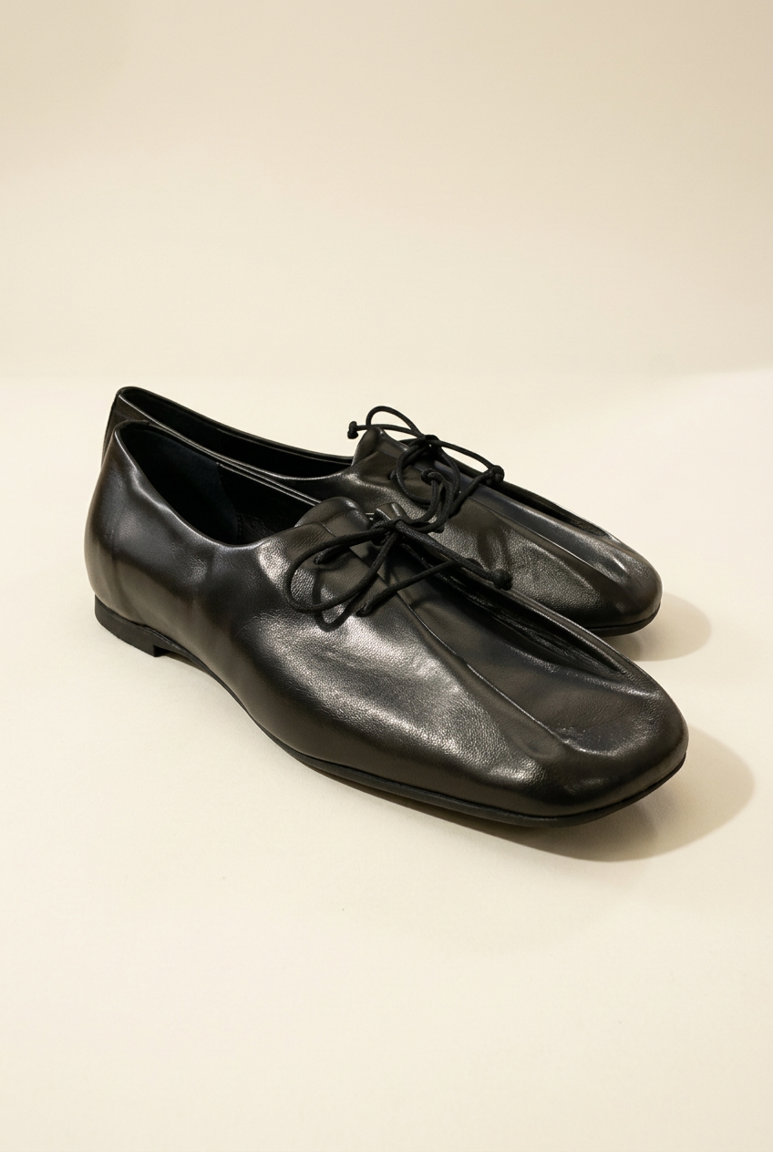 Scarpe 892 nere con lacci su sfondo avorio, vista a tre quarti