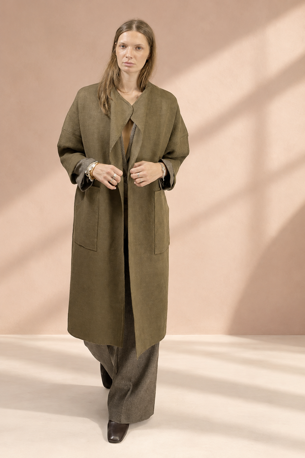 Cappotto Koh verde oliva, vista frontale su sfondo rosa argilla