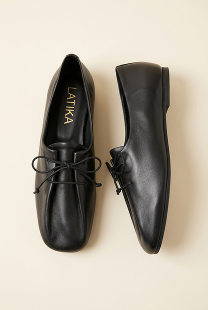 Scarpe 892 nere con lacci su sfondo avorio, dettaglio laterale