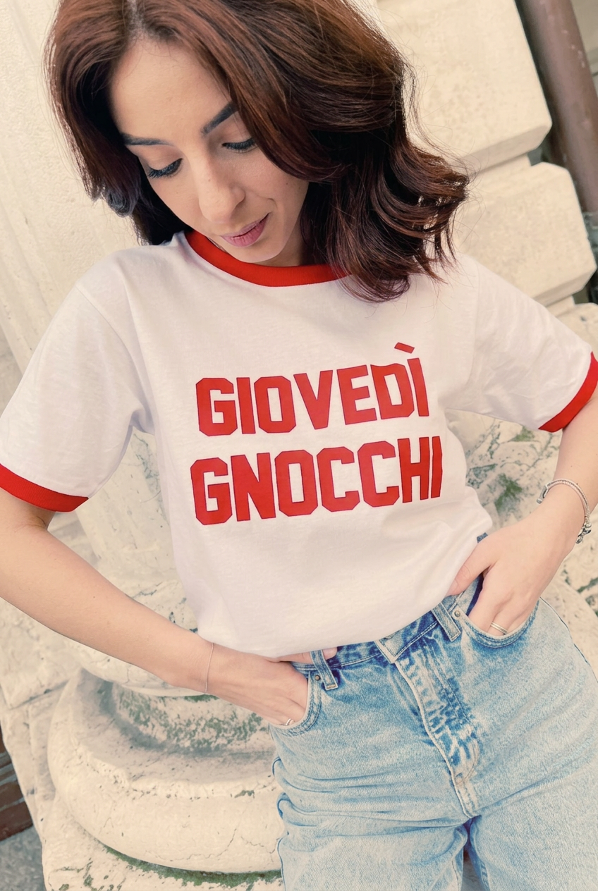Nuova modella indossa la T-shirt Giovedì Gnocchi nella posa originale con mani nelle tasche e sguardo in basso