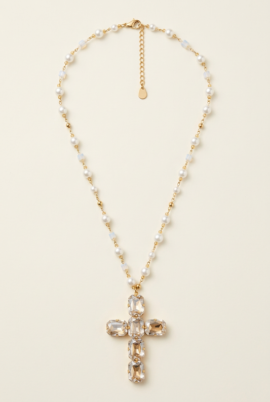 Collana Aura con perline effetto perla e croce luminosa su fondo avorio