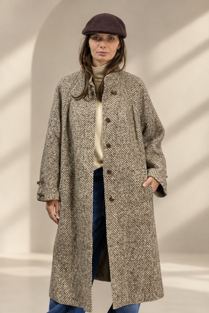 Cappotto Vintage a spina di pesce su sfondo greige da studio
