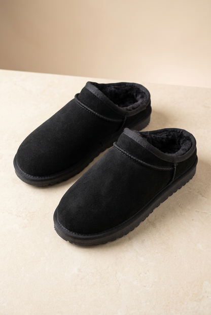 Scarpe 530 in camoscio nero appoggiate su fondo avorio