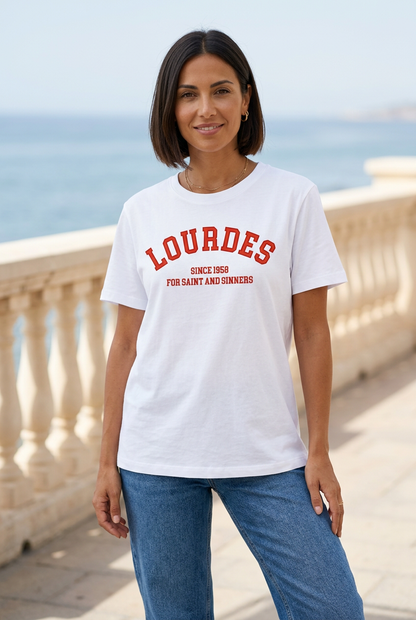 Modella con caschetto castano indossa la T-shirt bianca Lourdes con scritta rossa sul lungomare