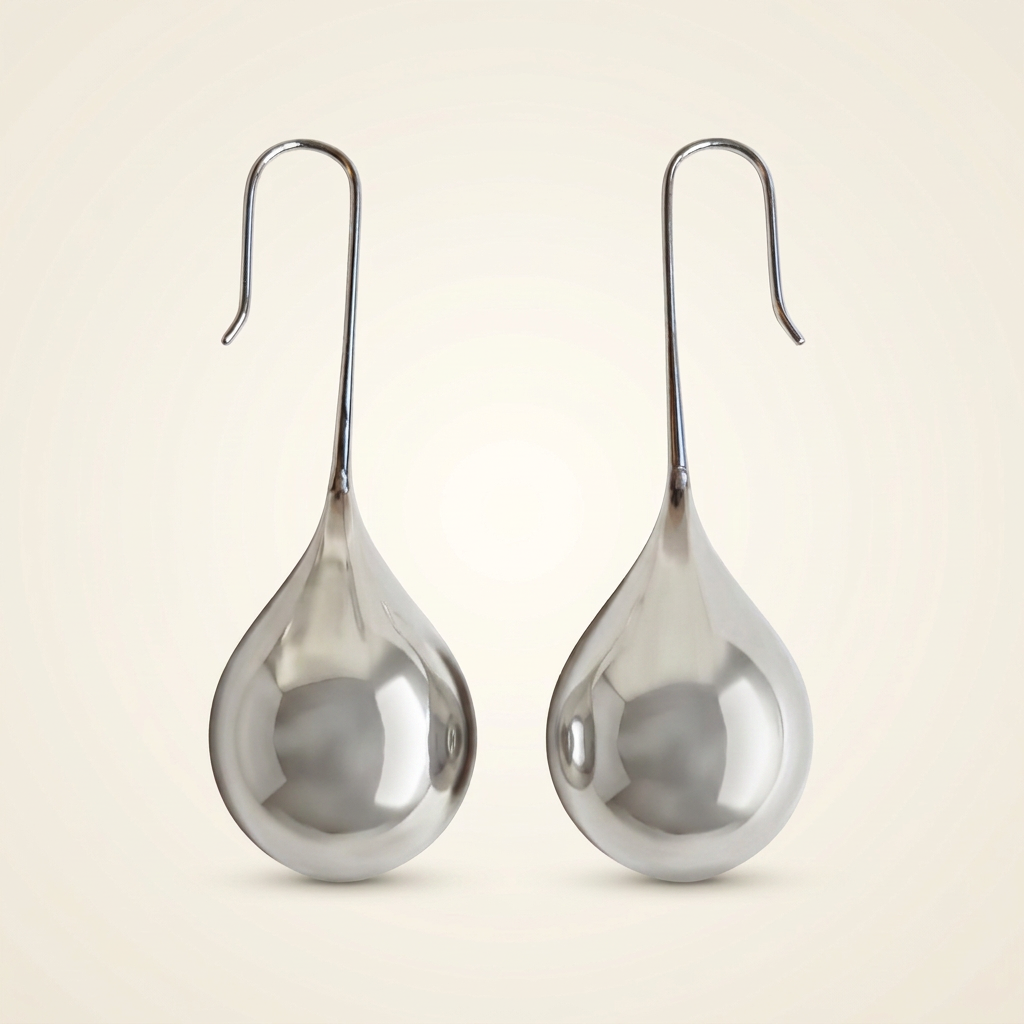 Orecchini Goccia Specchio color argento con superficie uniforme e ombre ridotte su fondo avorio