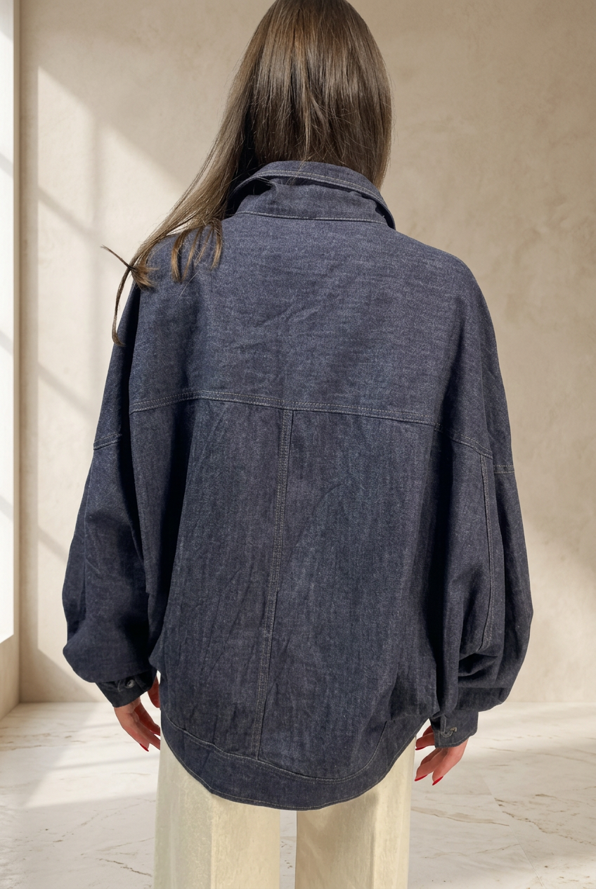 Giubbino 411 in denim scuro, vista posteriore su sfondo da studio color sabbia