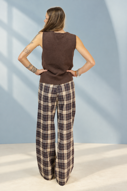Pantalone Checks a quadri marroni e crema, vista posteriore su sfondo azzurro polvere