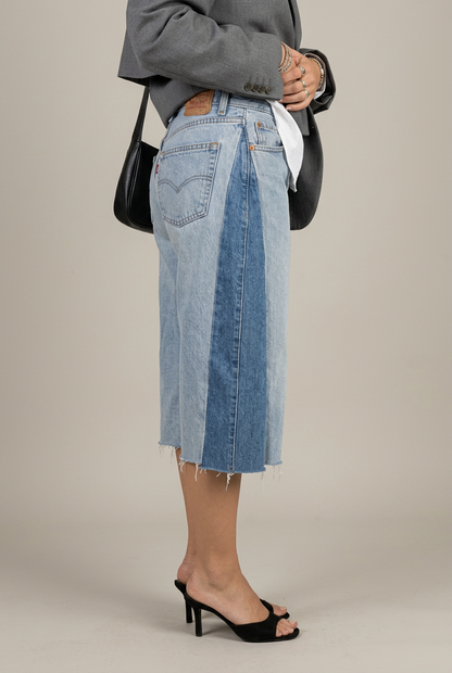 Bermuda Levi’s 2.8 con inserto laterale in denim scuro e orlo sfrangiato, vista laterale in studio