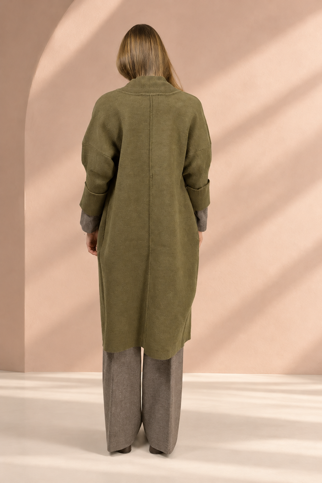 Cappotto Koh verde oliva, vista posteriore su sfondo rosa argilla