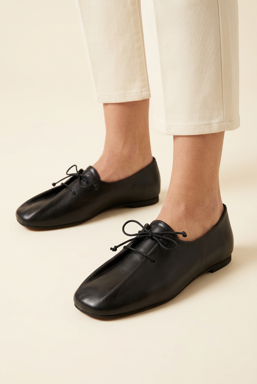 Scarpe 892 nere con lacci indossate dalla modella, primo piano su sfondo avorio