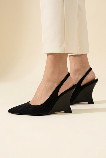 Scarpe Ruru nere indossate dalla modella, vista laterale della zeppa su sfondo avorio