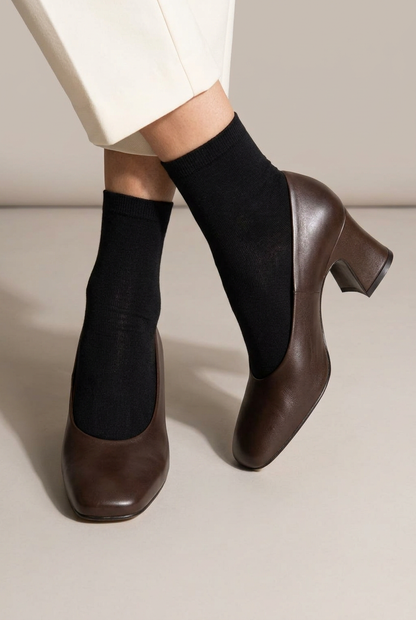 Scarpa Margot marrone indossata con calzino nero, primo piano su sfondo da studio
